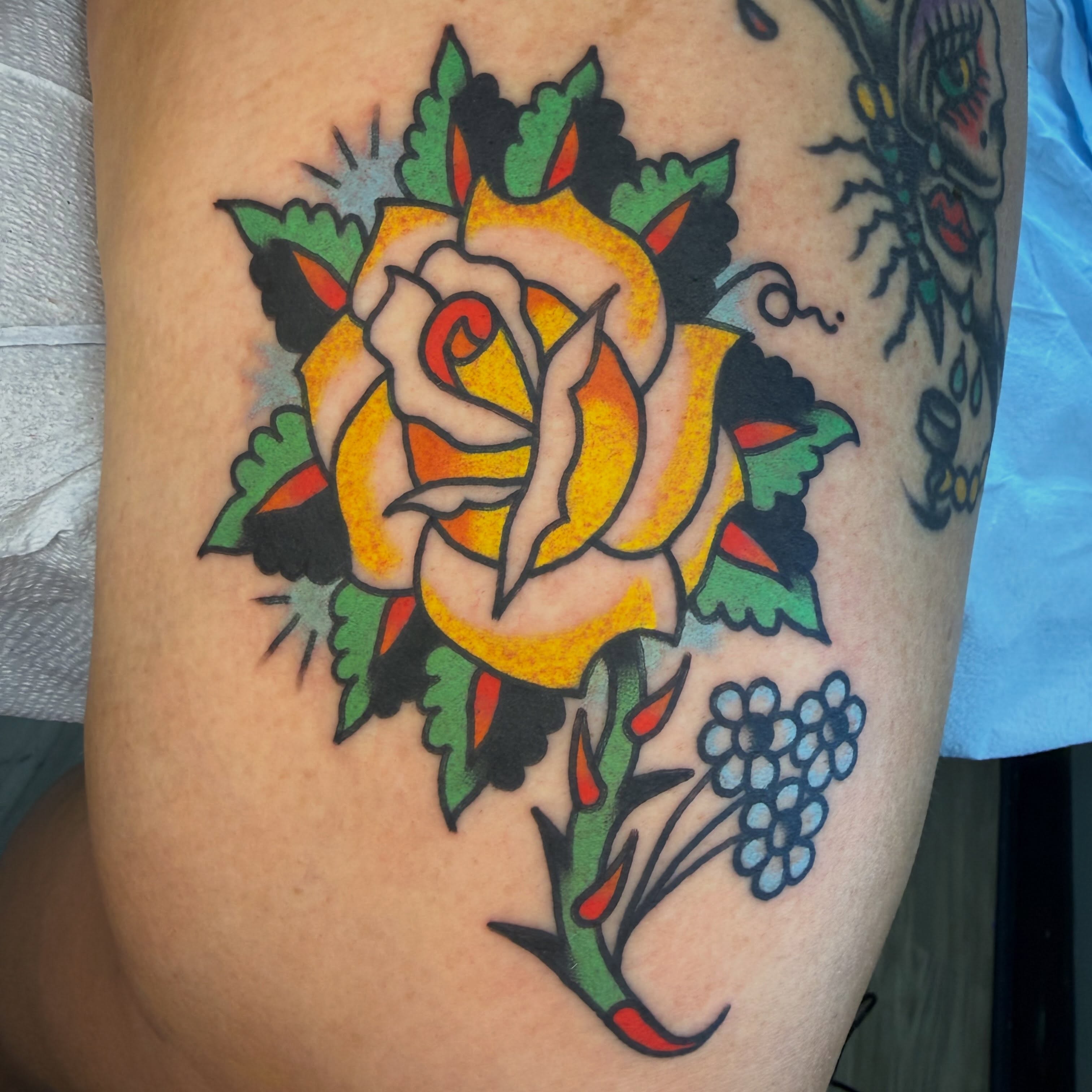 Yellow rose American traditional tattoo on the thigh by Tyler