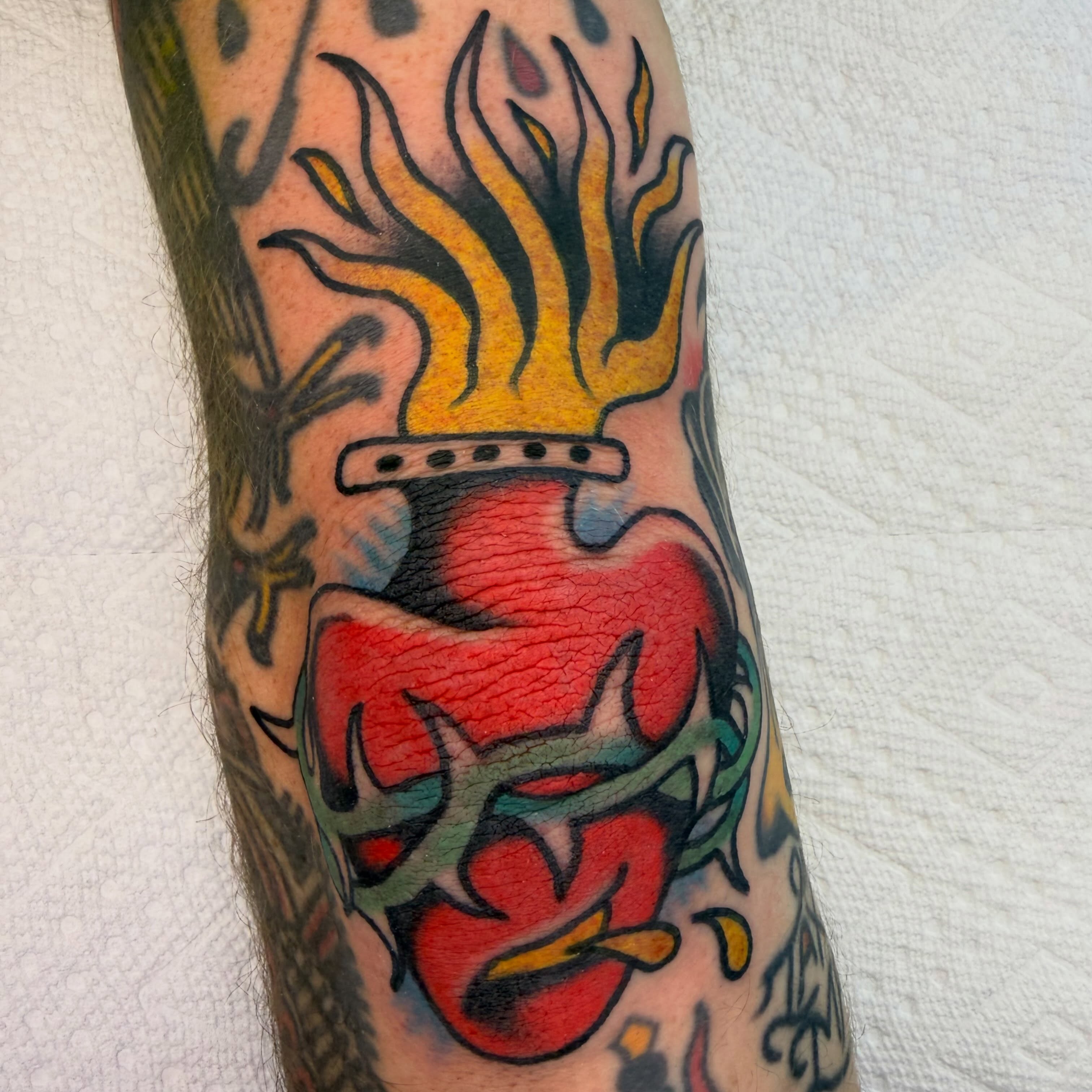 Flaming heart American traditional tattoo on the forearm by Tyler