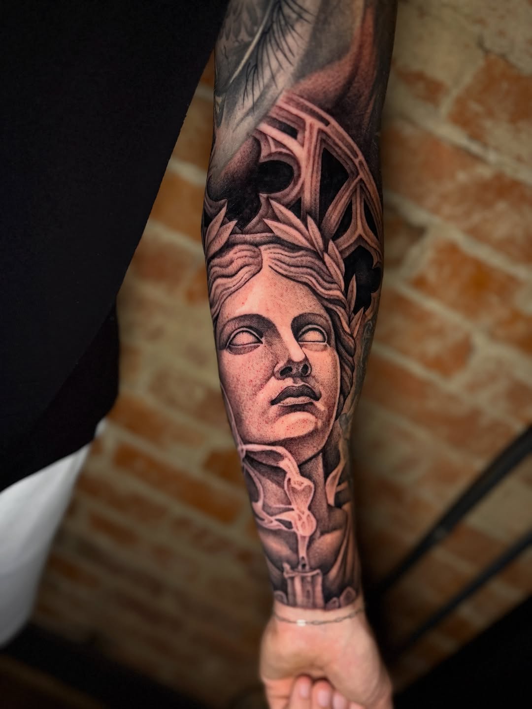 Statue head with candle and smoke surrealism tattoo on the forearm by Taylor Steckman