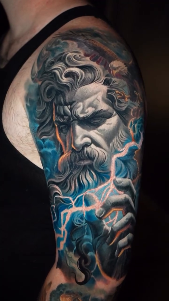Zeus portrait with lightning realism tattoo on the upper arm by Robert Morton, Cleveland, Ohio