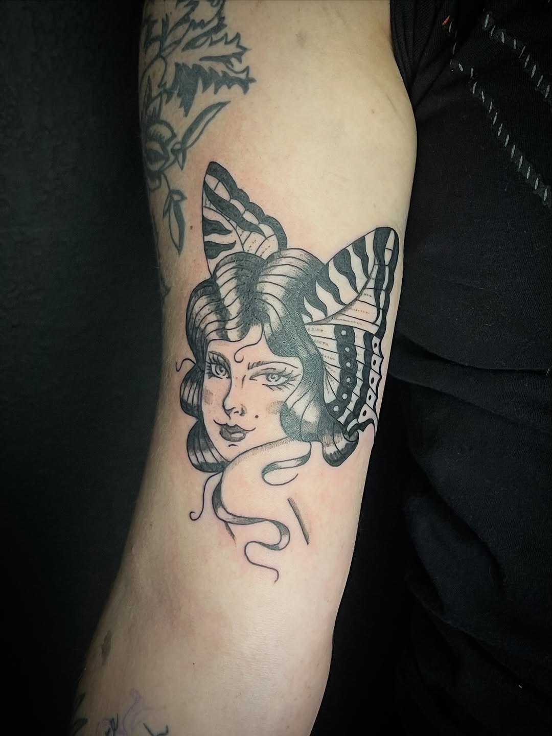 Woman's face with butterfly wings neo-traditional tattoo on the forearm by Rachel Hanke