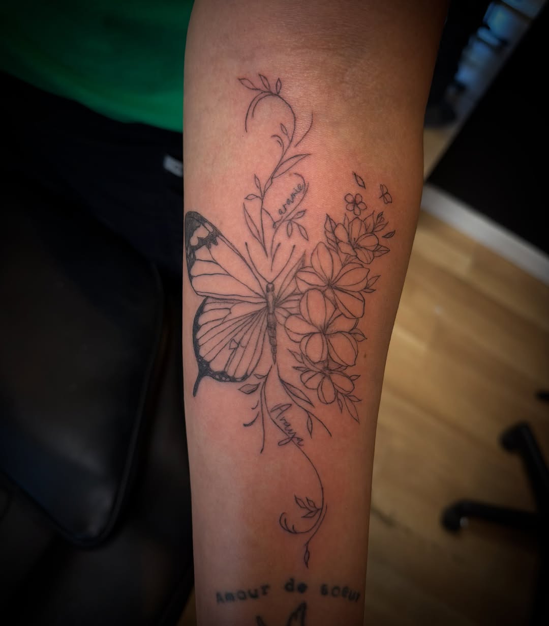 Butterfly and flowers with names fine line tattoo on the forearm by TolzinInk, Brookings, South Dakota