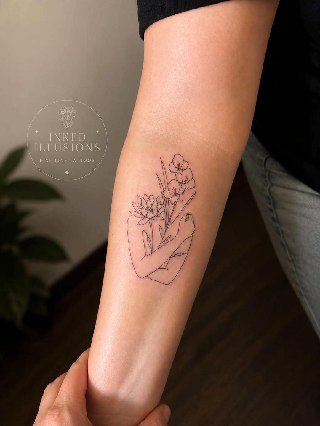 Figure embracing flowers fine line tattoo on the forearm by Victoria Cooper
