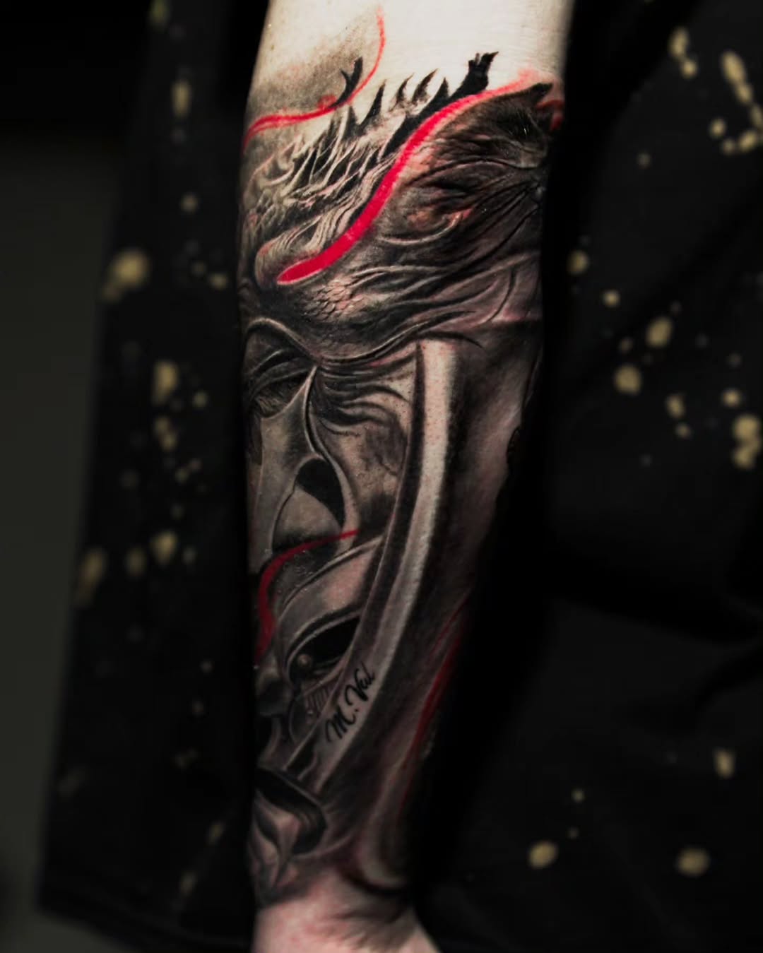 Mask with red accents realism tattoo on the forearm by Baxtertattoo