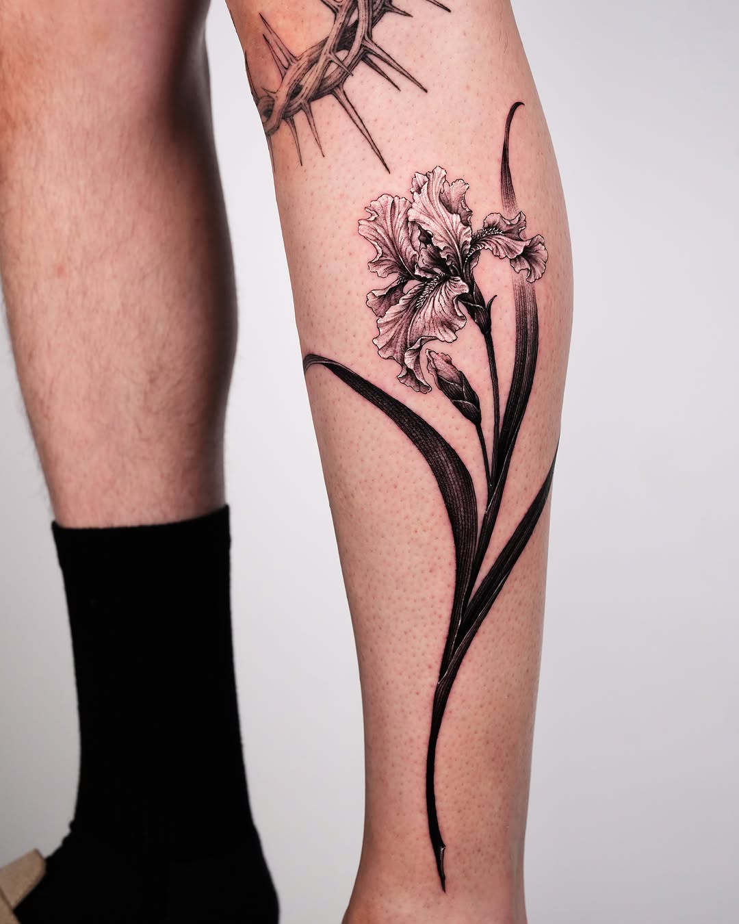 Iris flower blackwork tattoo on the calf by Intat