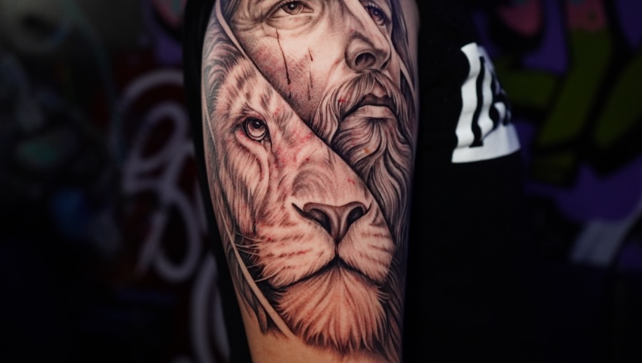 Lion and human face Chicano tattoo on the forearm by Abel Ponce