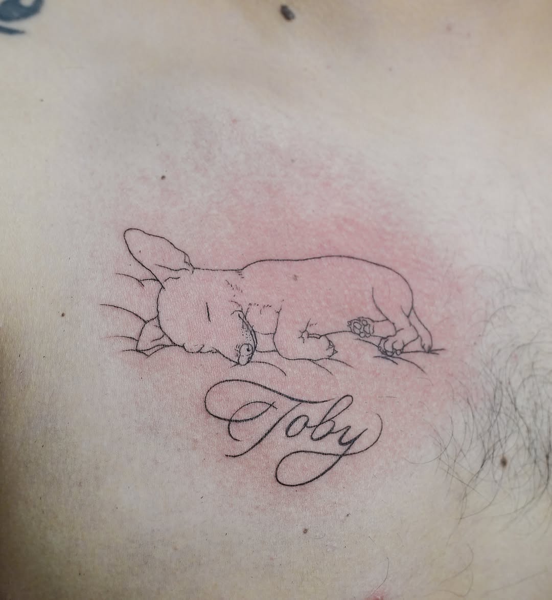 Sleeping dog with name realism tattoo on the chest by Hery Anwar