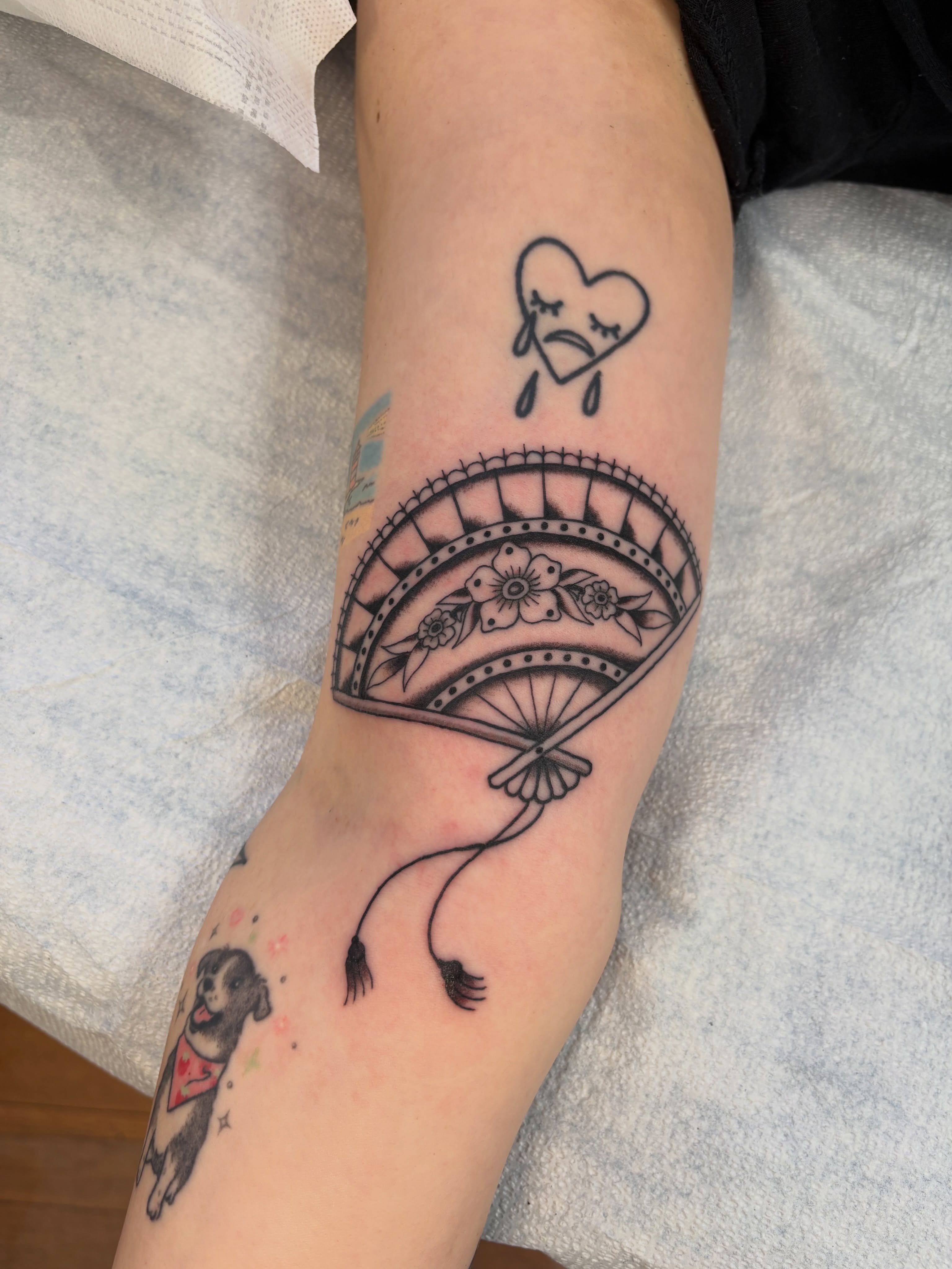 Fan with flowers black and grey tattoo on the forearm by 𝓰𝓲𝓷𝓪 𝓼𝓮𝓻𝓹𝓮𝓷𝓽𝓲𝓷𝓪