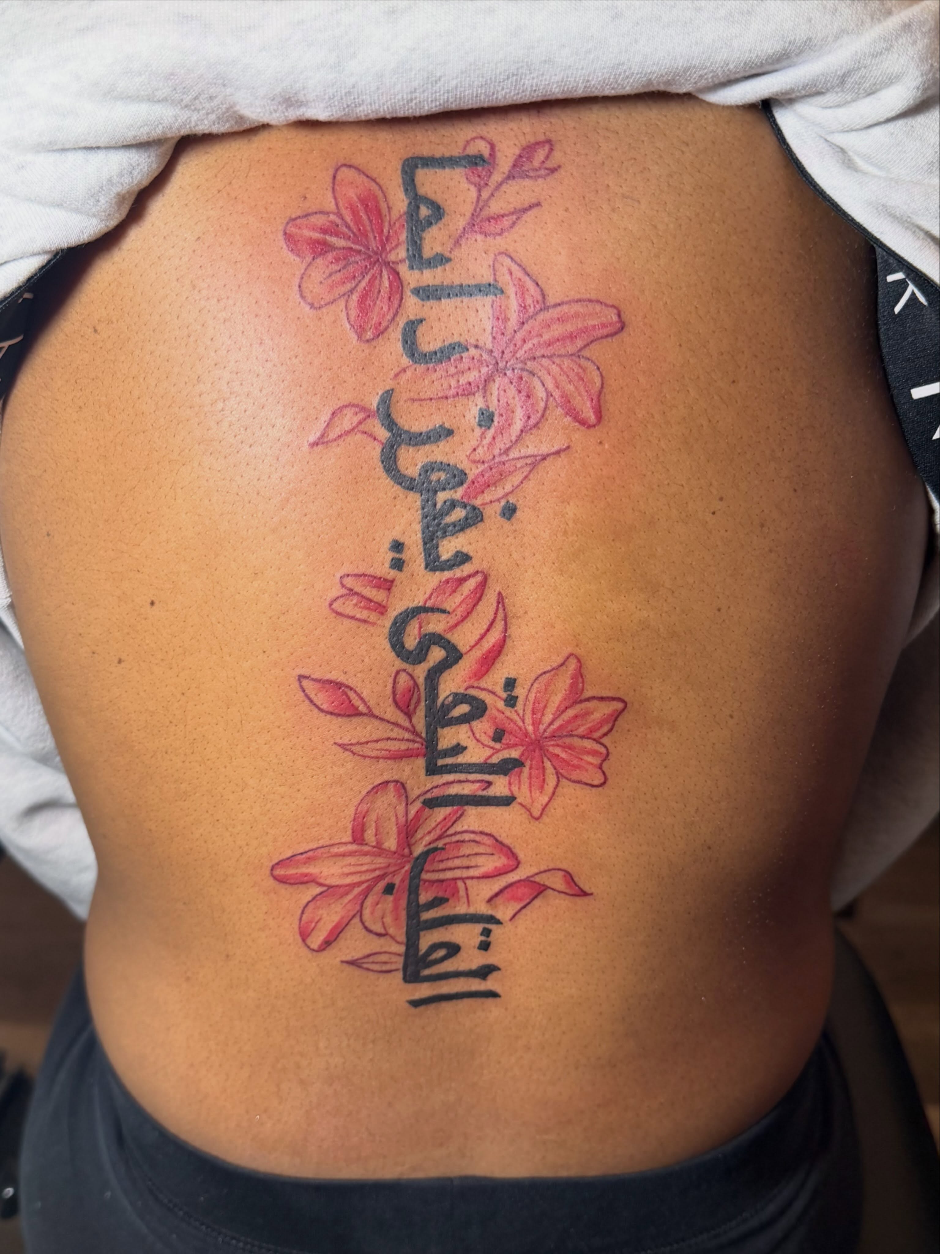 Floral script fine line tattoo on the ribs by Tattoosbydevon