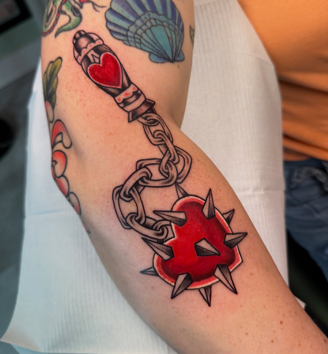 Heart with spikes American traditional tattoo on the forearm by Liz Aulenbacher