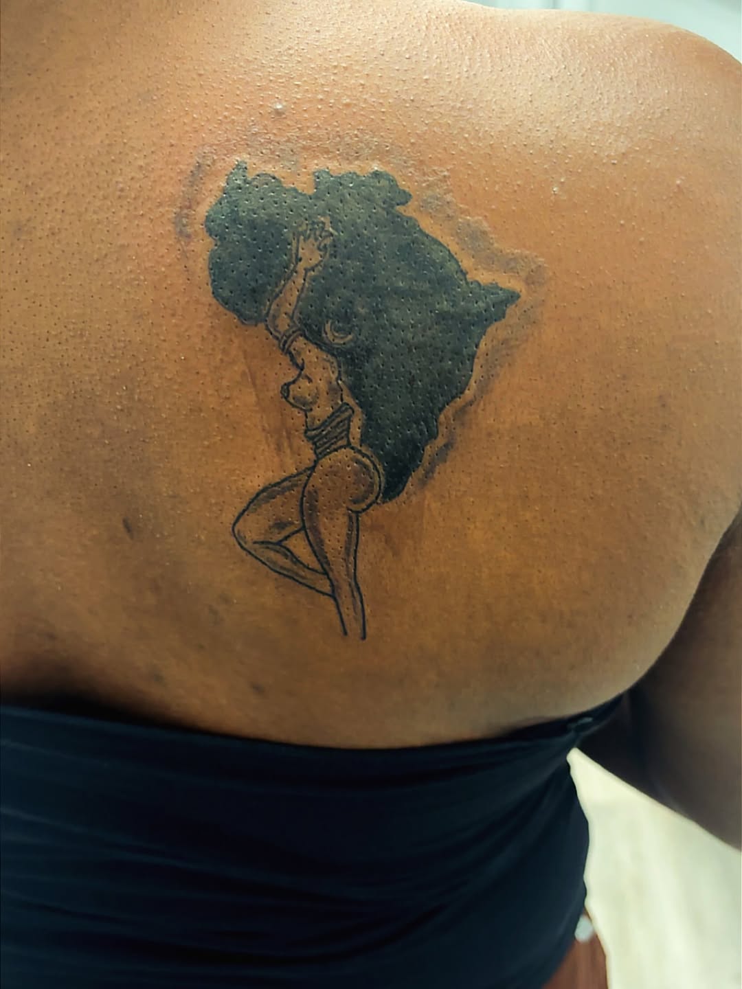 Woman in africa shape tattoo on the back by Syneca Wilson, Acton, Massachusetts