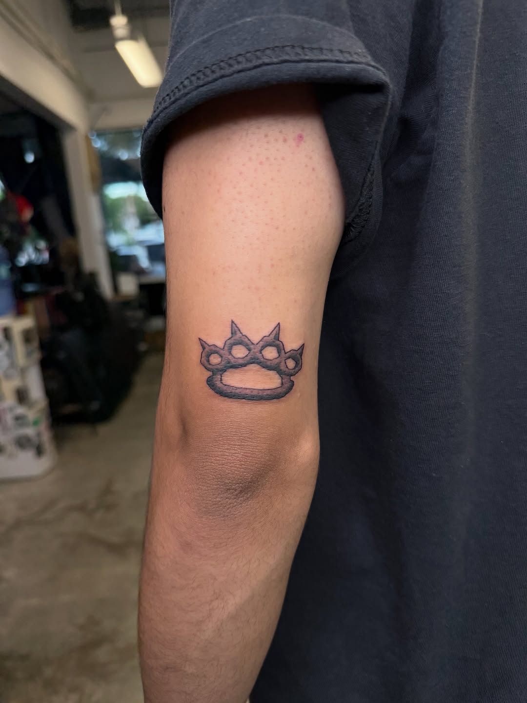 Brass knuckles tattoo on the forearm by Ricky Sanchez, Duncanville, Texas