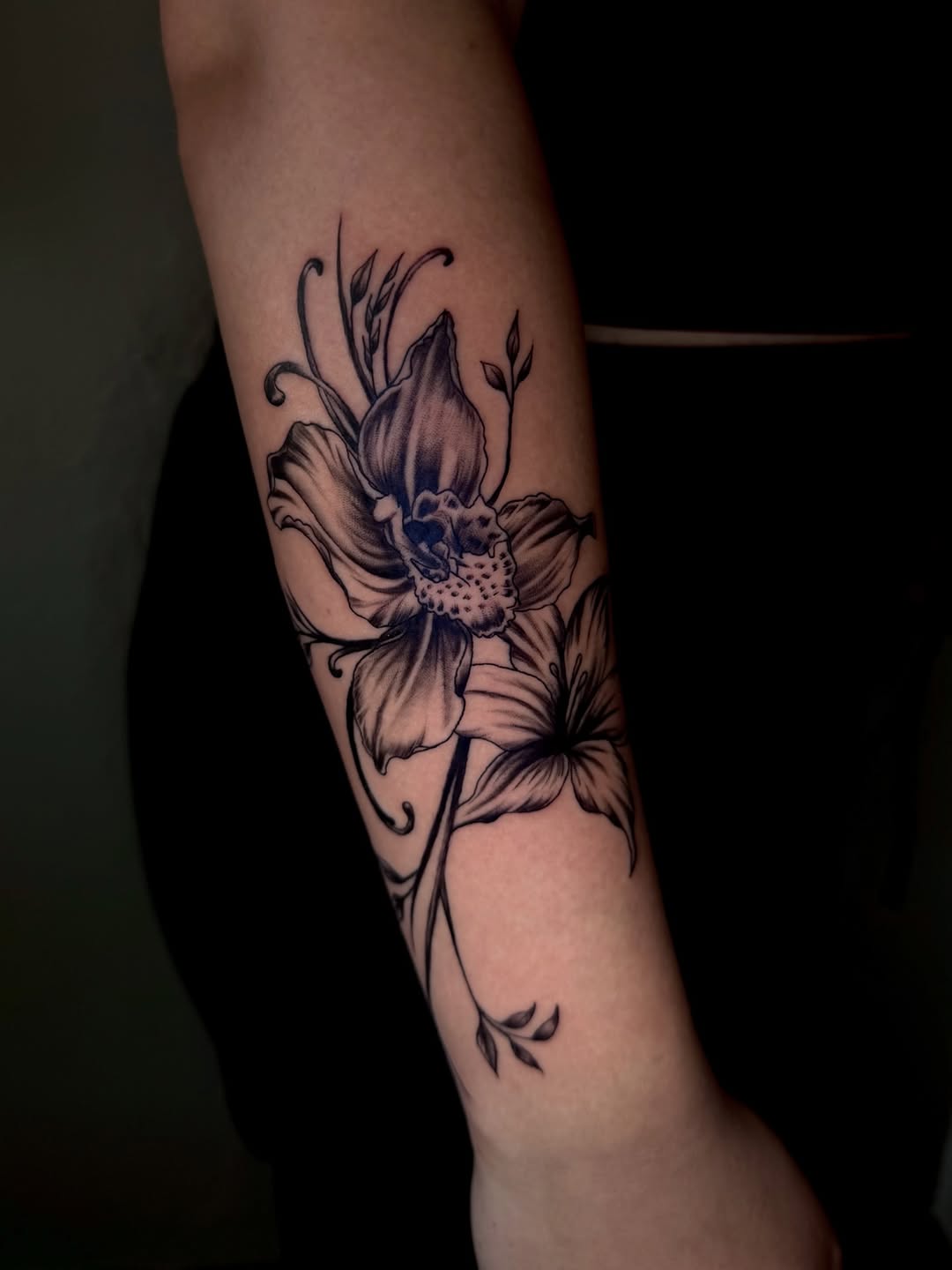 Orchid and lily flowers fine line tattoo on the forearm by jayla pantig