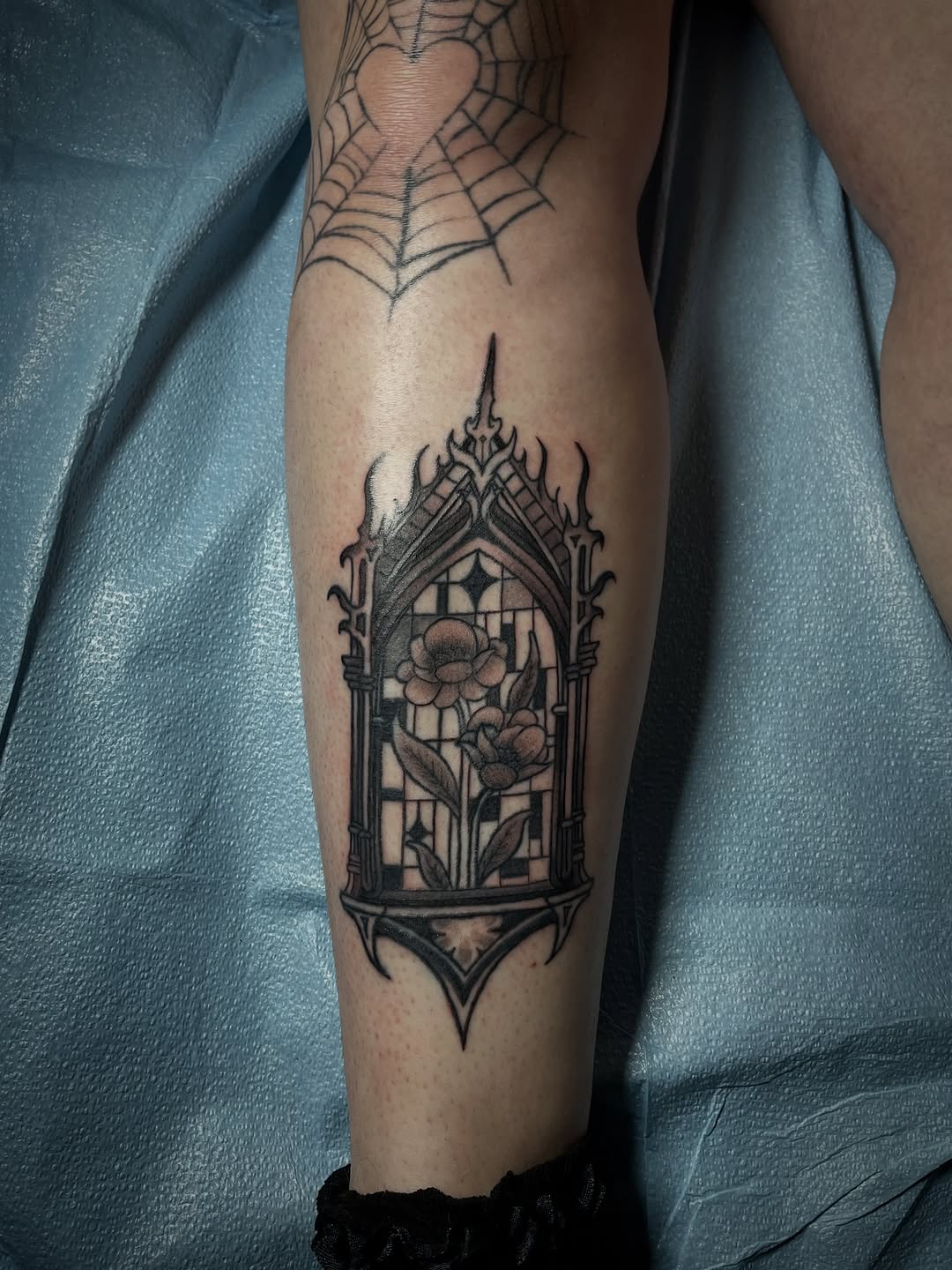 Gothic window with flowers dark art tattoo on the forearm by The Reelist Ink