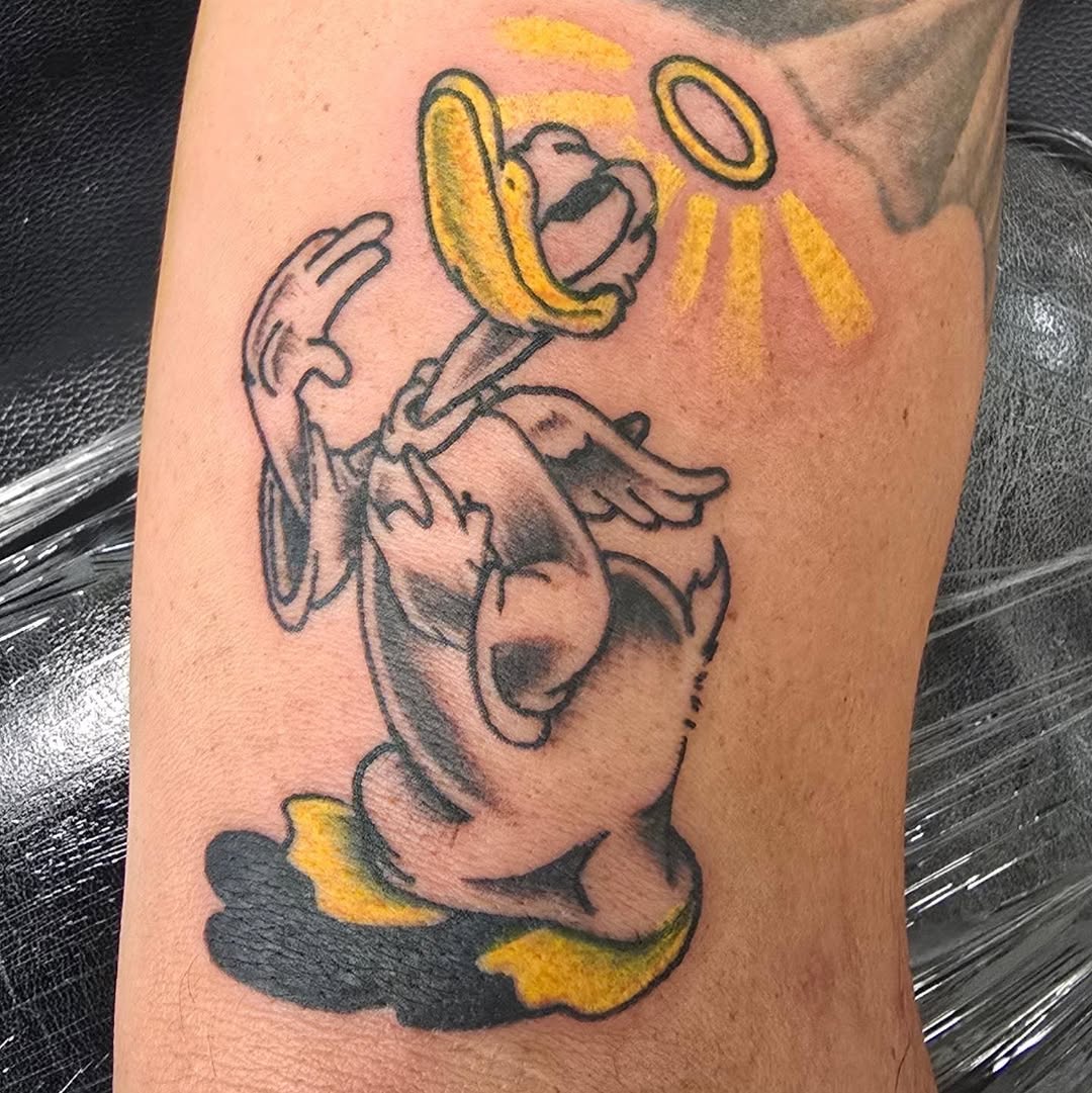 Donald Duck with halo new school tattoo on the forearm by Captain Michael Devious
