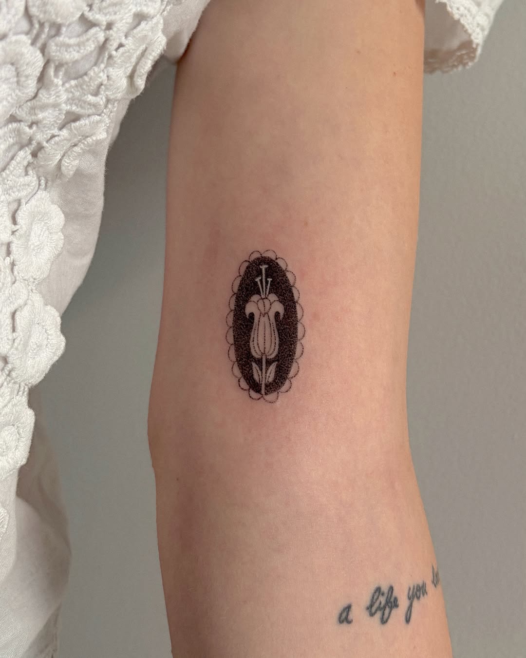 Tulip in oval frame minimalist tattoo on the forearm by alli ミ☆