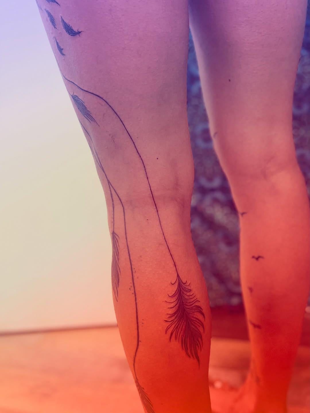 Feathers and birds fine line tattoo on the leg by La Main Bleue