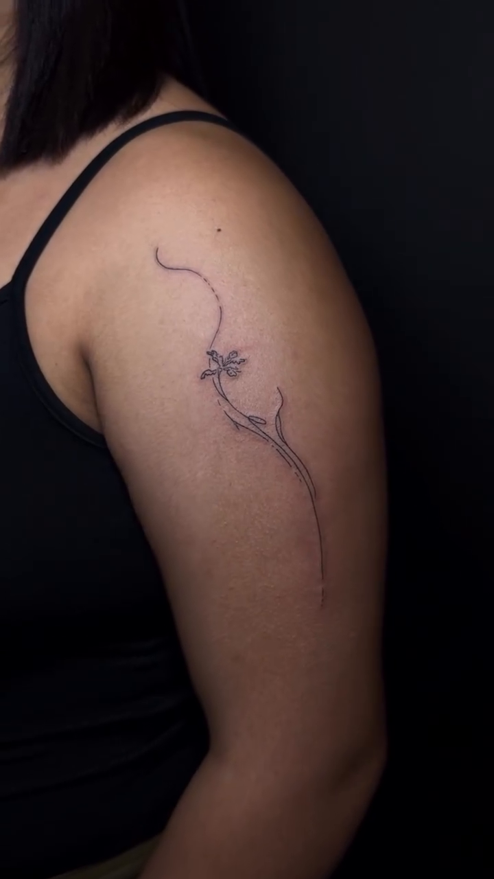 Dragonfly on a branch minimalist tattoo on the shoulder by Pretty Ugly Tattoos