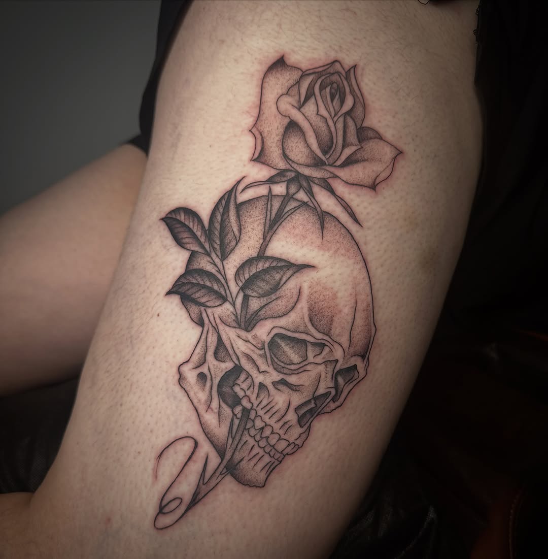 Skull with rose and leaves realism tattoo on the thigh by Lia Massari
