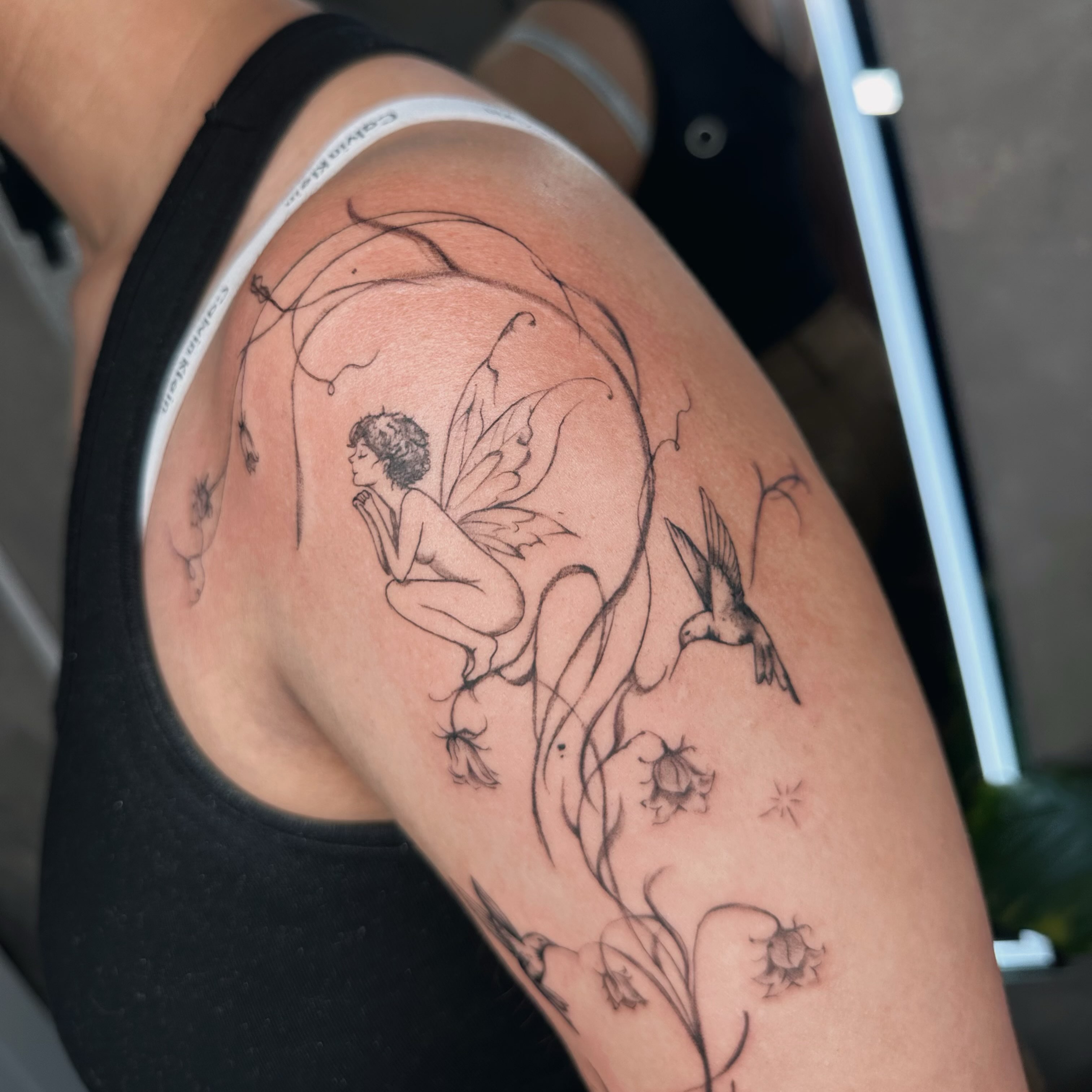 Fairy and bird fine line tattoo on the thigh by Liv