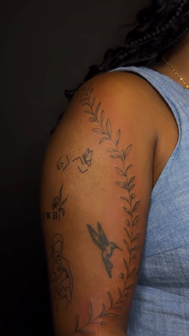 Hummingbird and floral vine tattoo minimalist tattoo on the upper arm by Pretty Ugly Tattoos