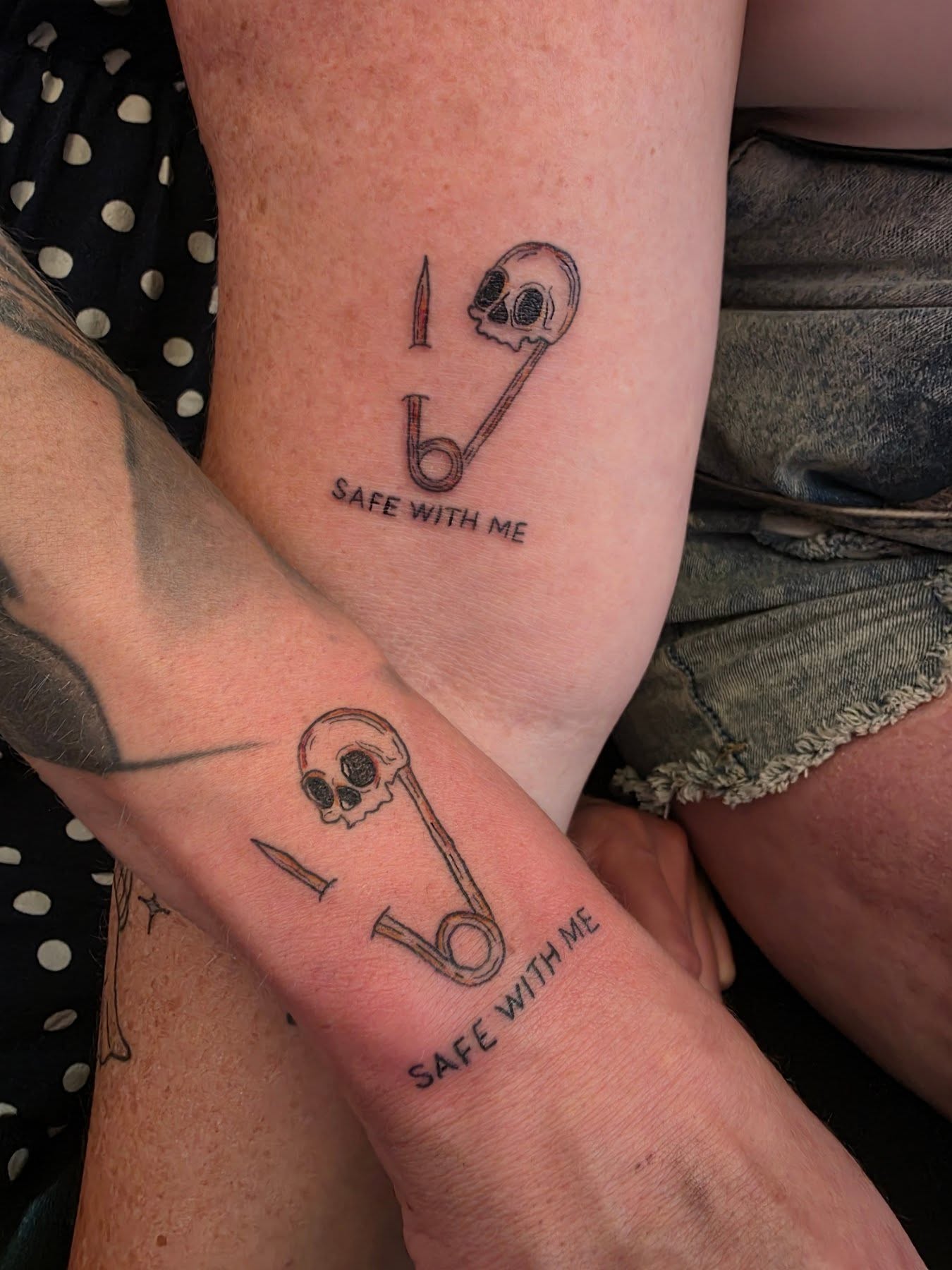 Safety pin and skull black and grey tattoo on the forearm by Danyelle Becker
