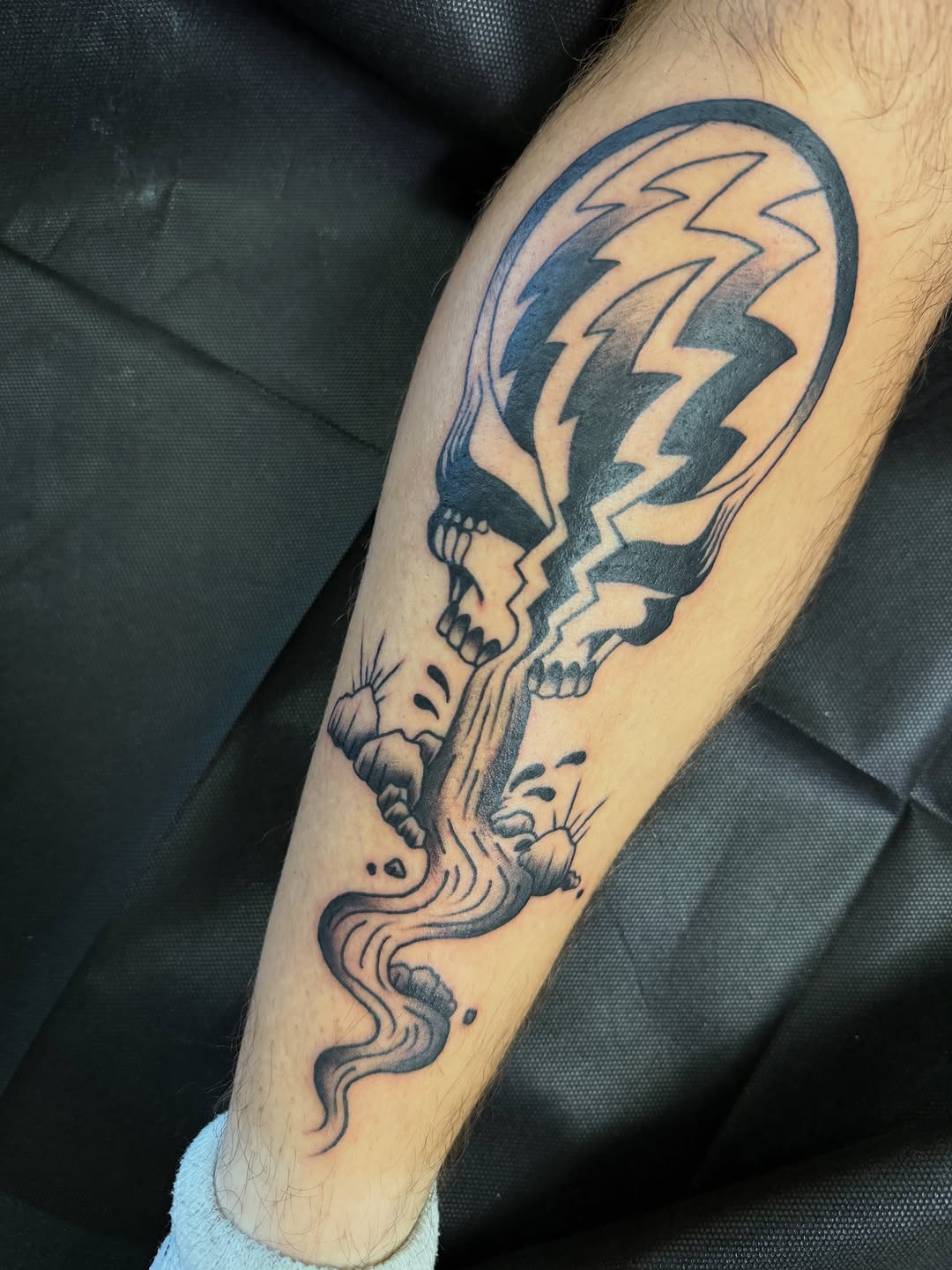 Skull with lightning and water dark art tattoo on the forearm by Nick Tumminello