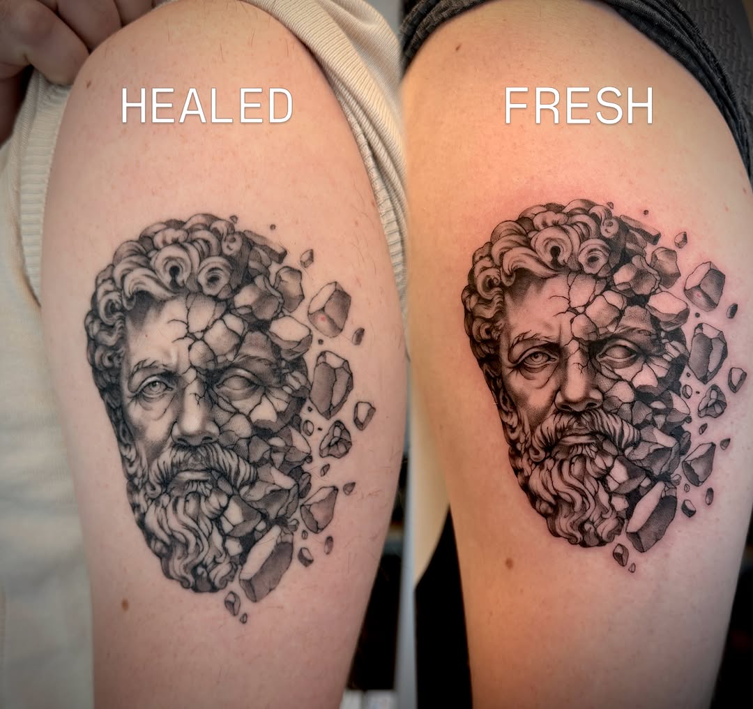 Statue head dissolving surrealism tattoo on the shoulder by Aristova Anastasia