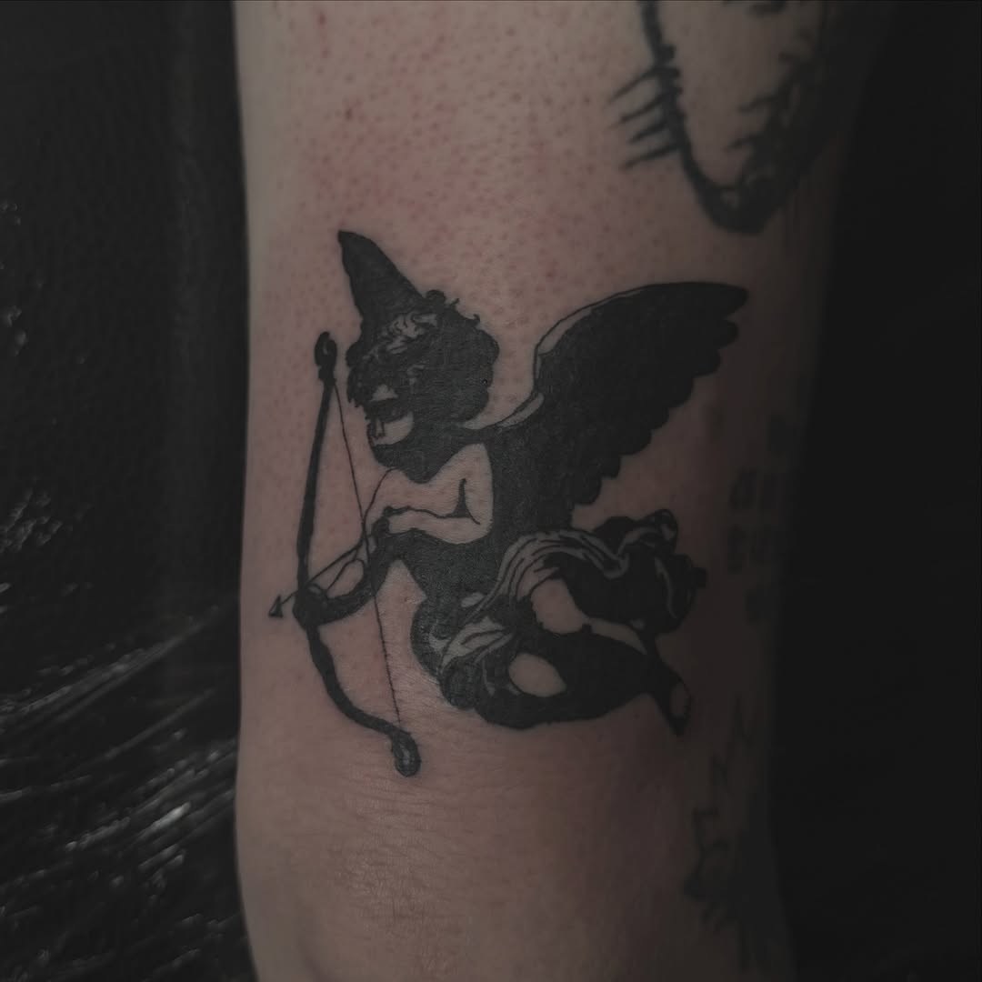 Cherub with bow and arrow ignorant tattoo on the forearm by Jordan Sandoval