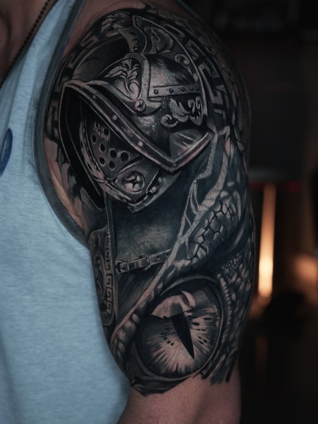 Gladiator helmet and dragon eye realism tattoo on the shoulder by Andres García Baeza