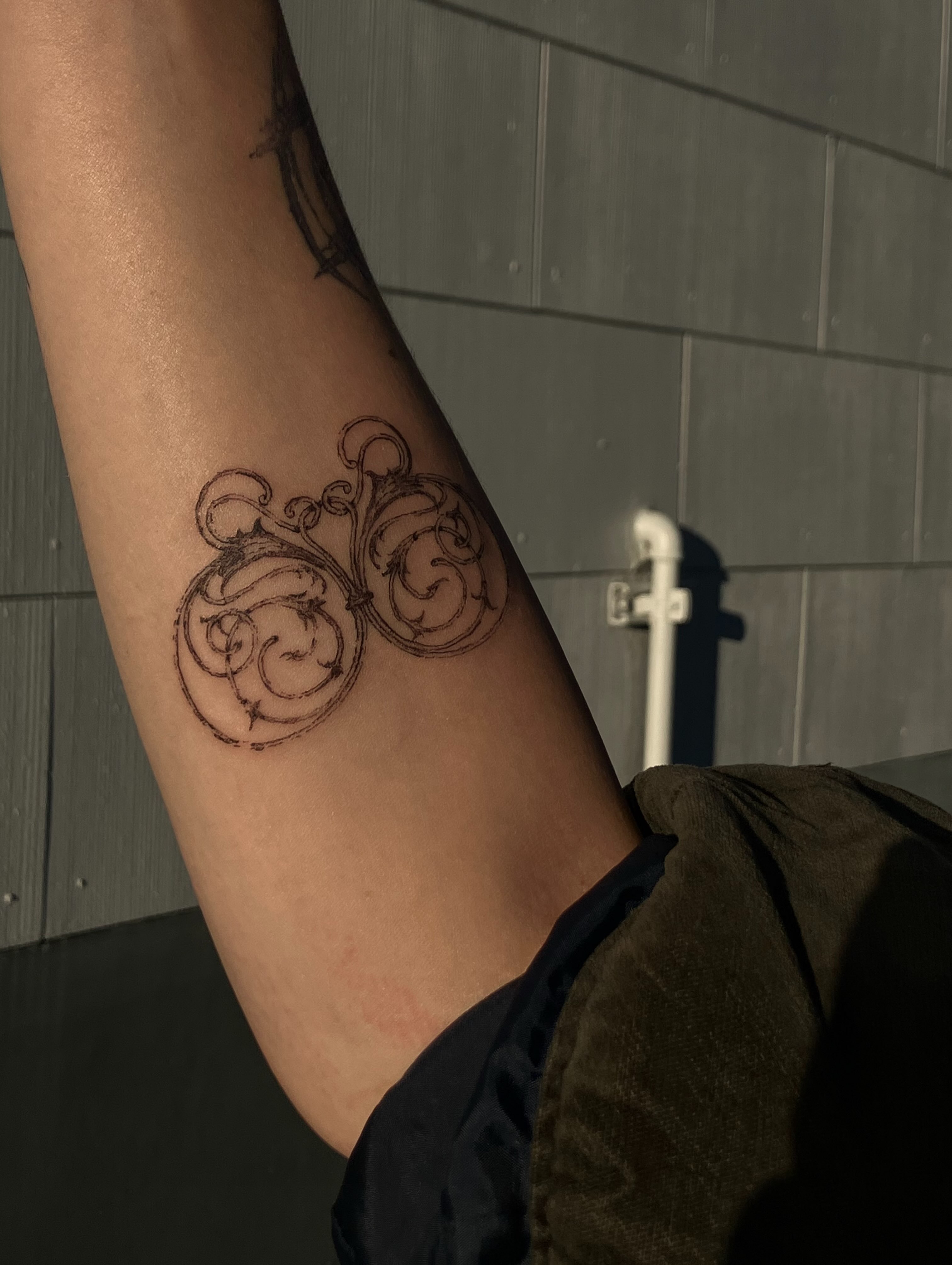 Scrollwork black and grey tattoo on the forearm by Sashka