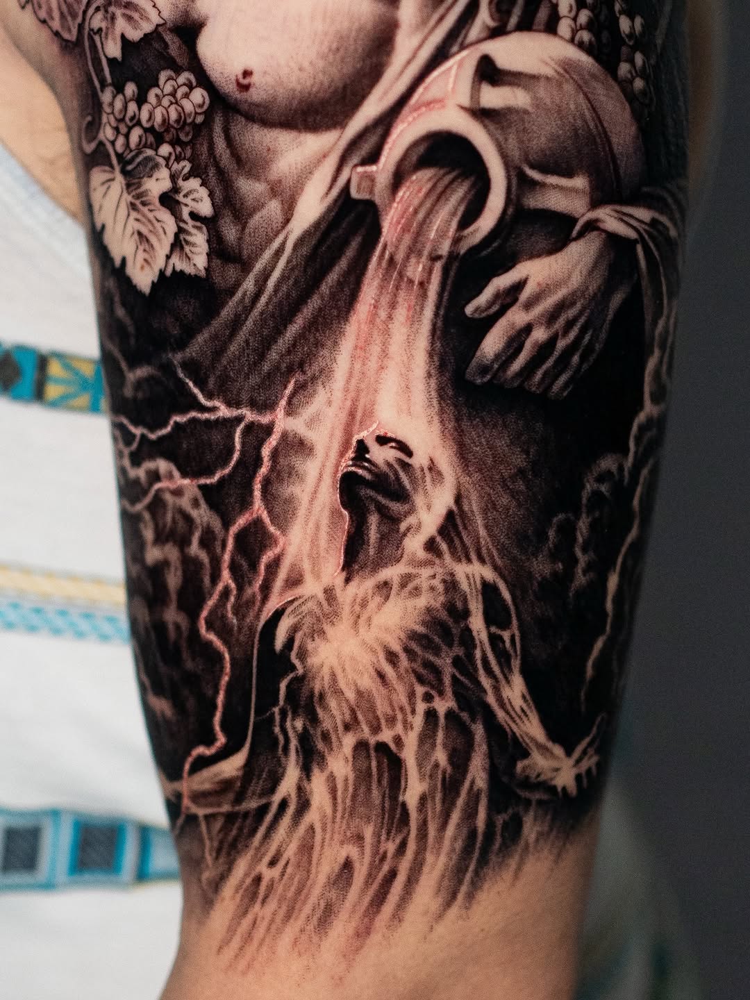 Figure pouring water from a jug realism tattoo on the forearm by Mark Vata