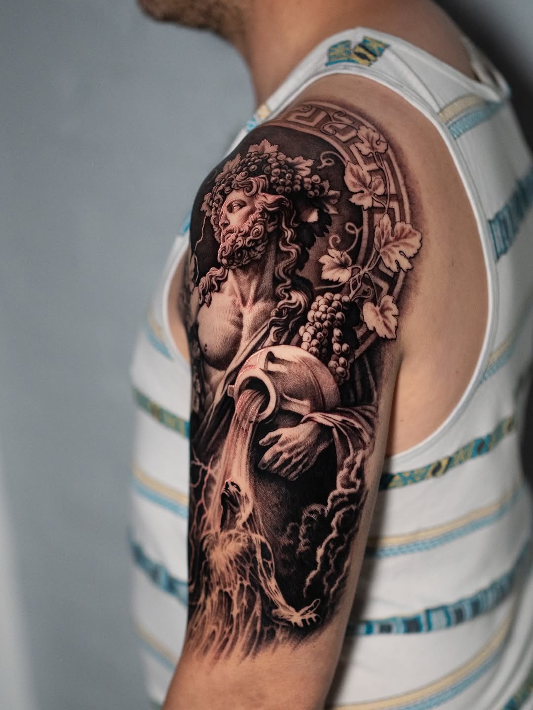 Bacchus pouring water realism tattoo on the shoulder by Mark Vata