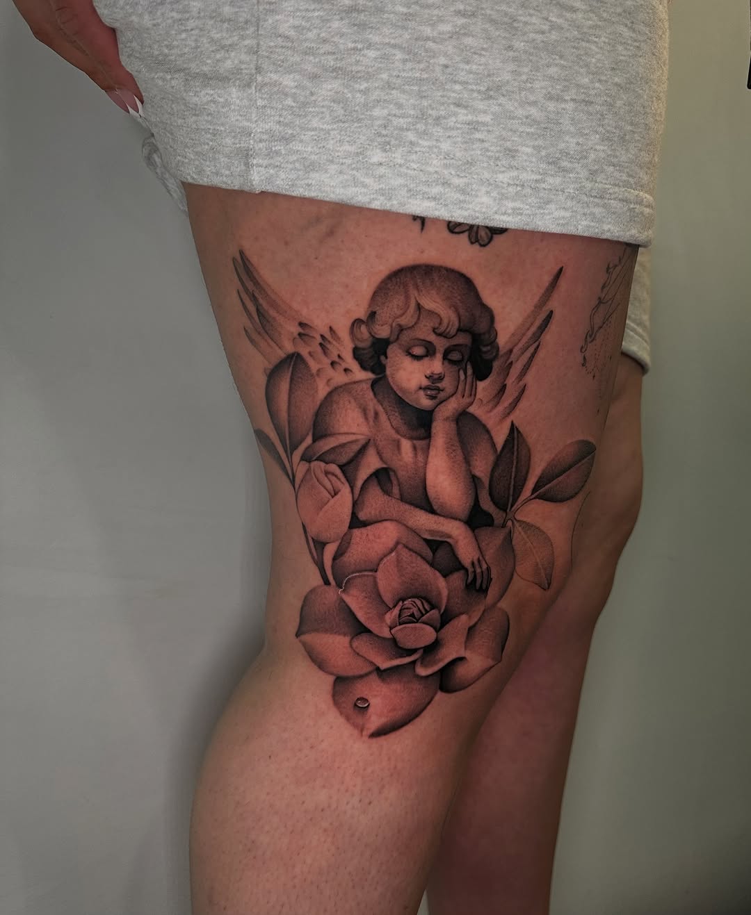 Cherub with rose realism tattoo on the thigh by @piinkywabbiit, Roselle Park, New Jersey