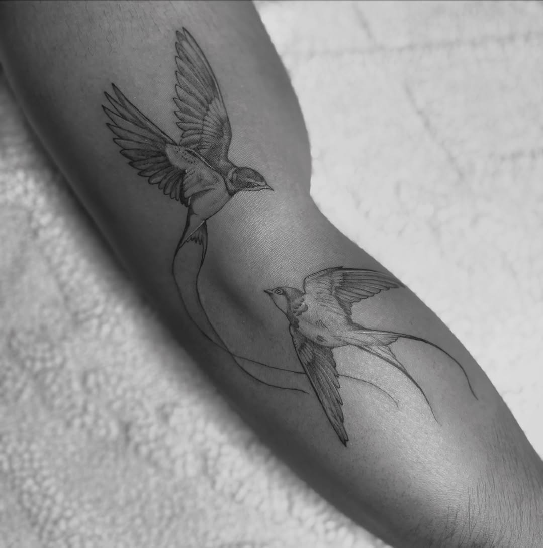 Swallows black and grey tattoo on the forearm by @secretlinetattoo