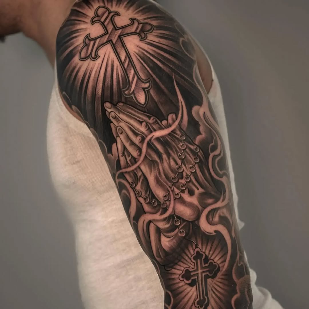 Praying hands with crosses and rosary Chicano tattoo on the forearm by ink.alchemist