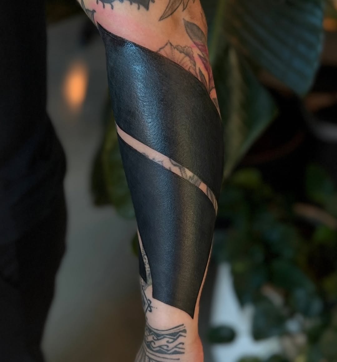 Abstract blackwork tribal tattoo on the forearm by Rachel