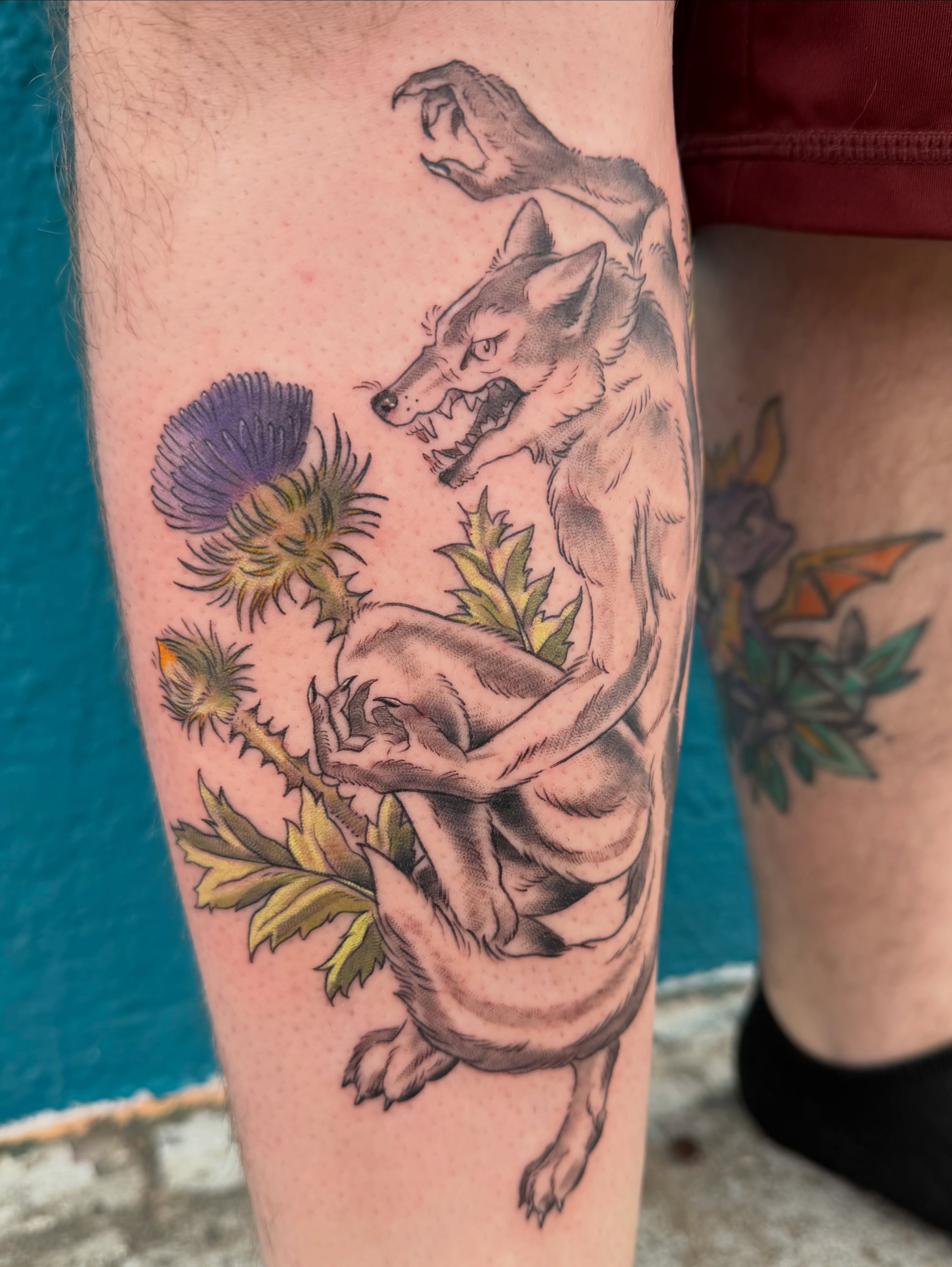 Wolf and thistle American traditional tattoo on the thigh by Roswell Orellana 👽🛸