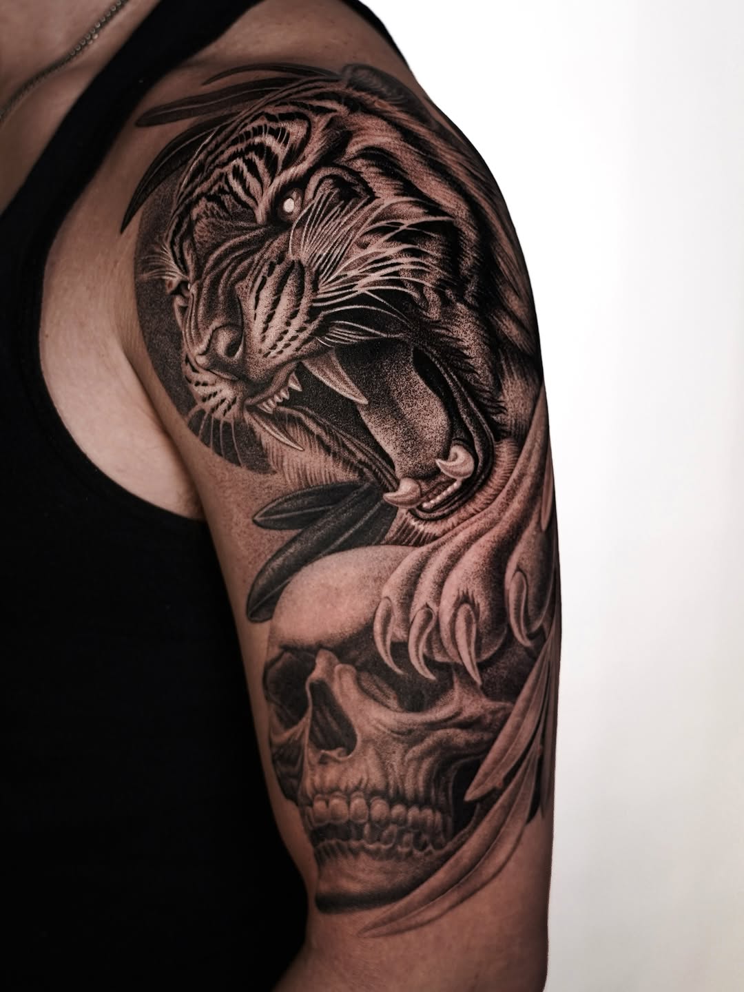 Tiger and skull realism tattoo on the upper arm by Enrique Martinez