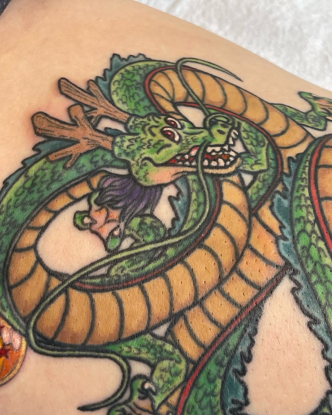 Shenron dragon from Dragon Ball Z American traditional tattoo on the upper arm by Ashley Antolin