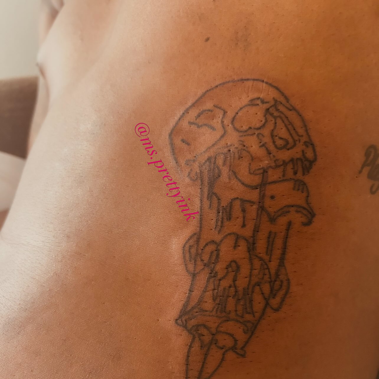 Skull and dripping black and grey tattoo on the upper arm by Airika Edwards
