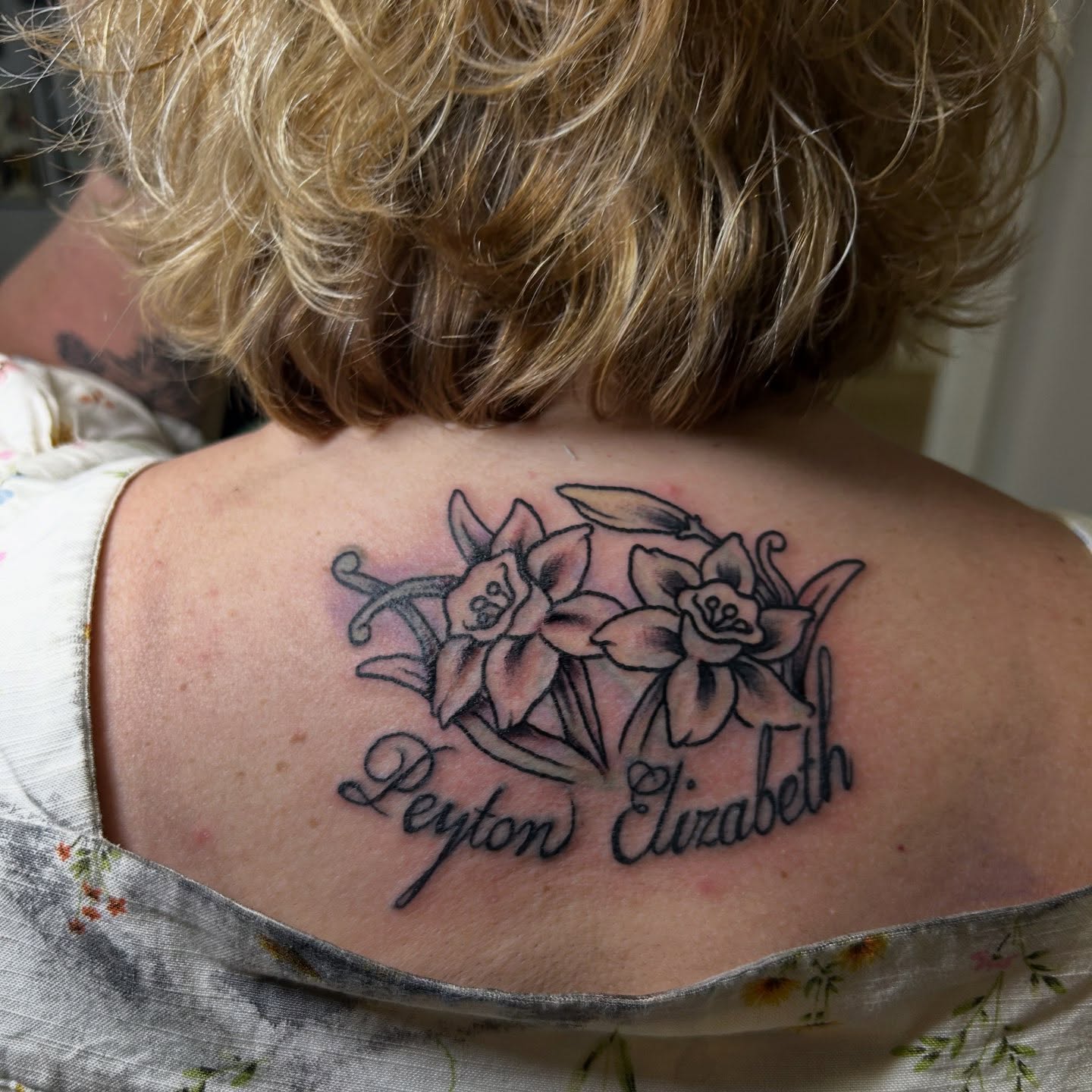 Flowers and names black and grey tattoo on the back by Sarah π€π»