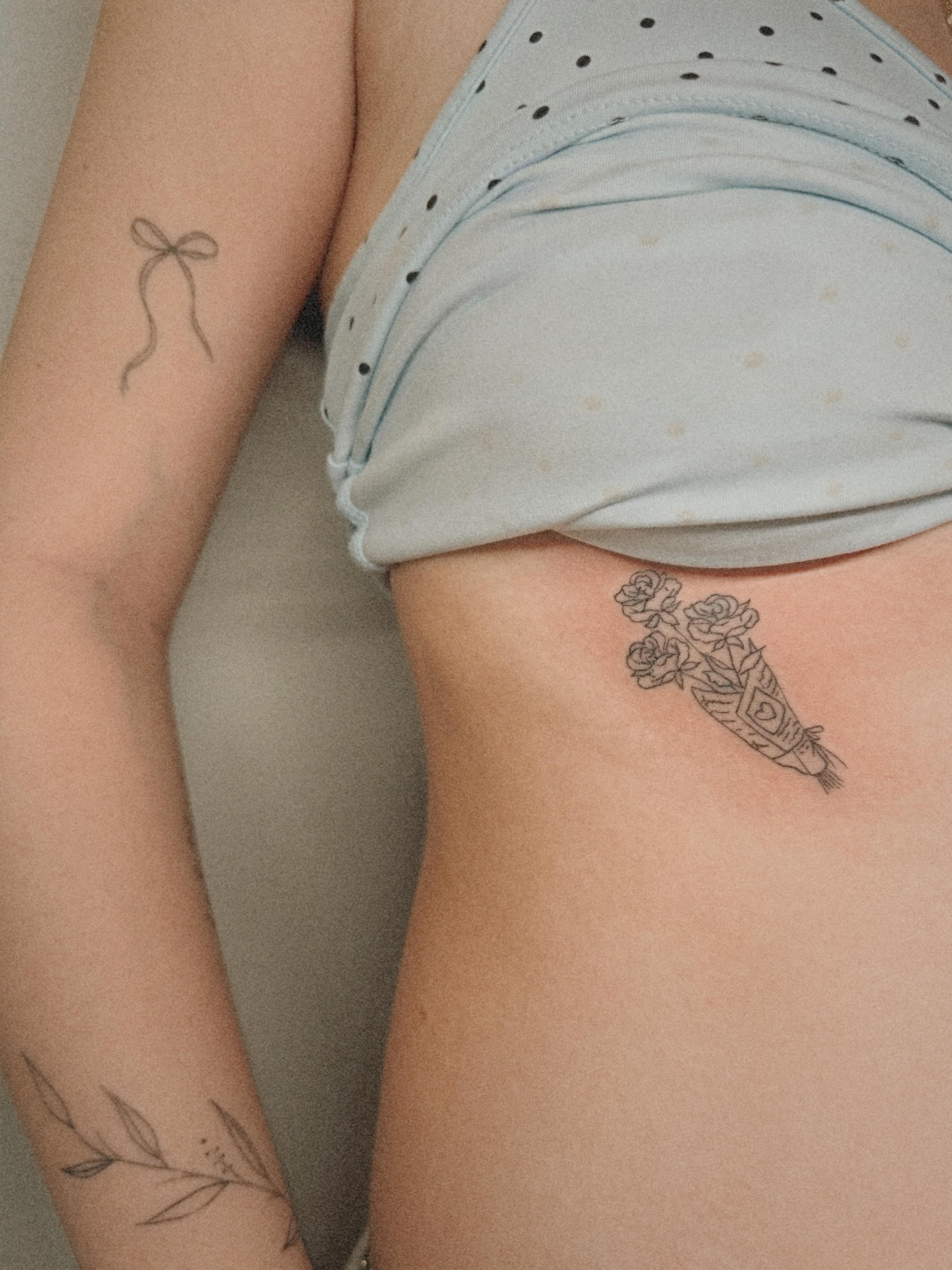 Roses and feather black and grey tattoo on the thigh by Ashlee Burkey