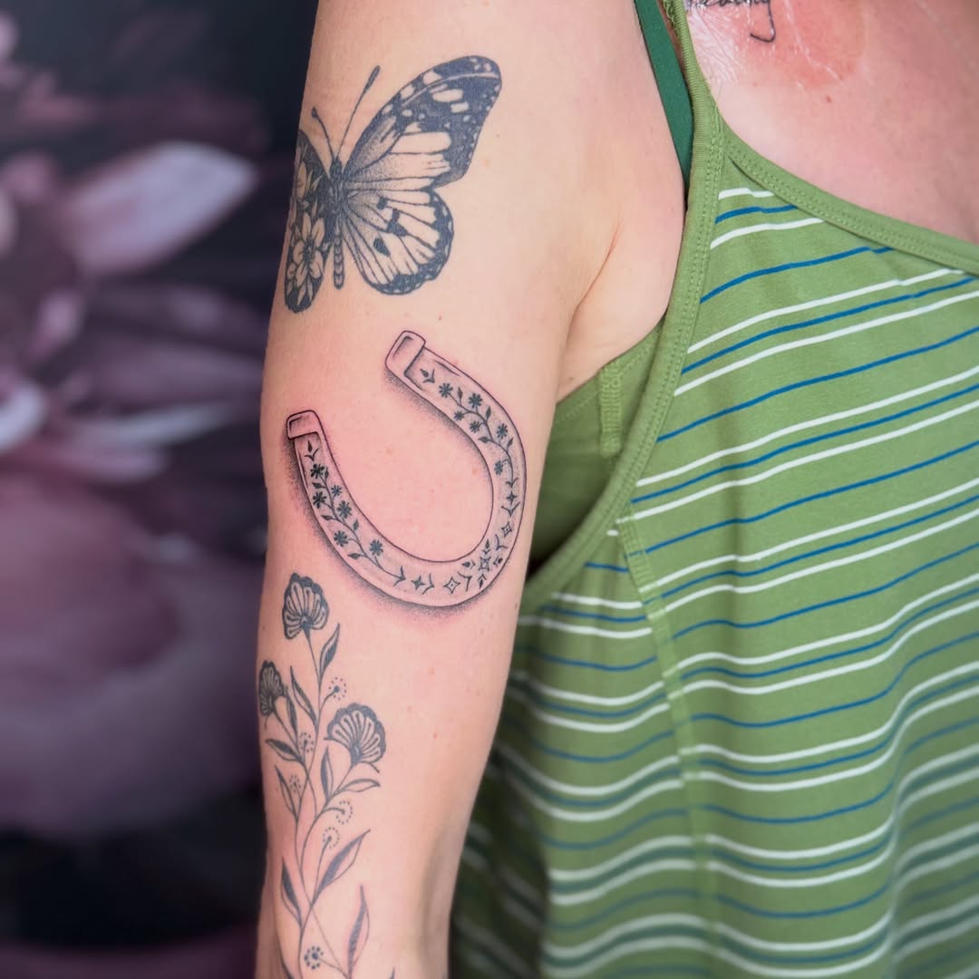 Horseshoe with floral pattern American traditional tattoo on the forearm by Van Cleave Aesthetics, Franklin, Tennessee