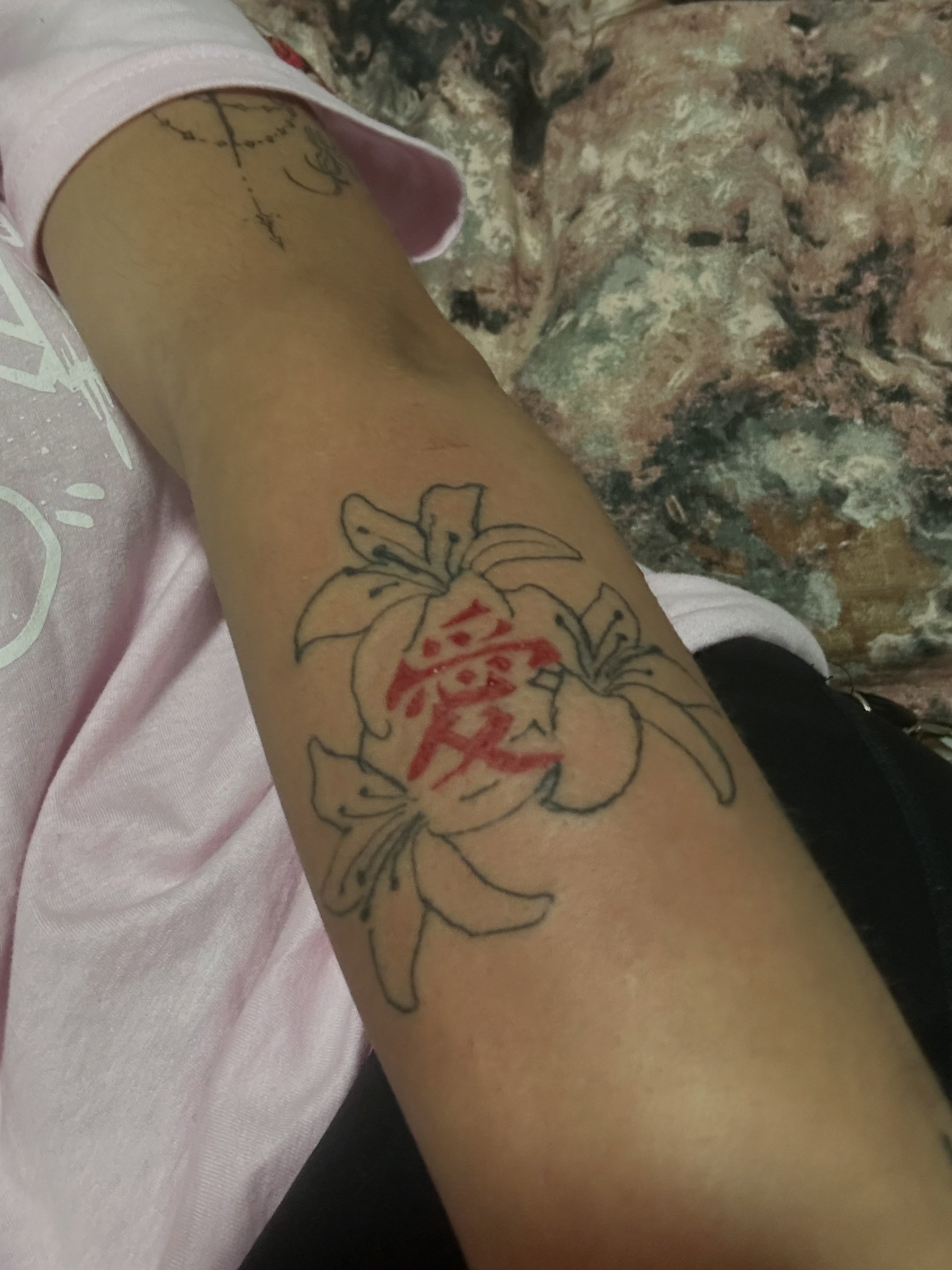 Lily and kanji black and grey tattoo on the forearm by The feminine ink