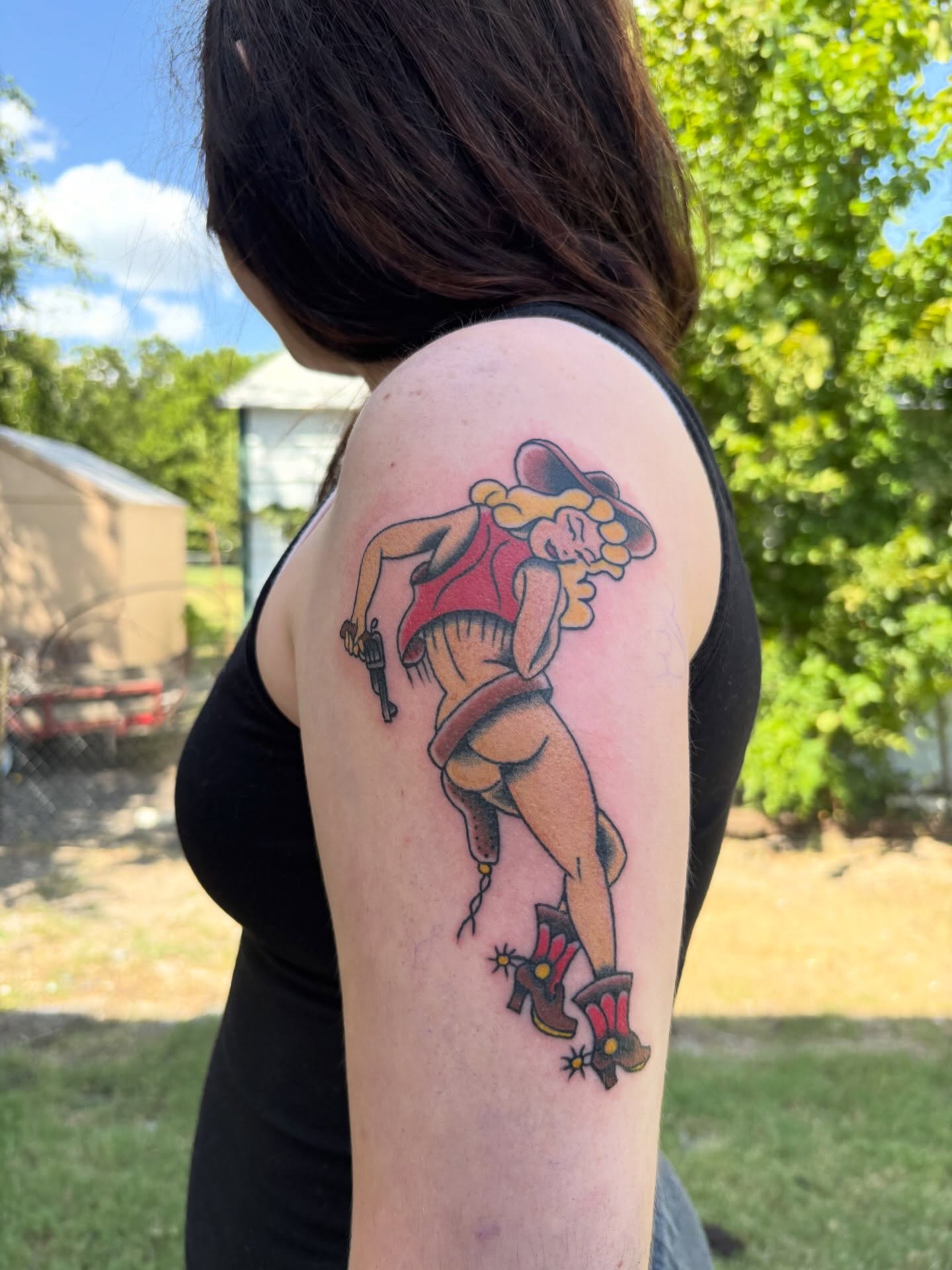 Cowgirl pin-up American traditional tattoo on the upper arm by Ethan Ellis, Dallas, Texas