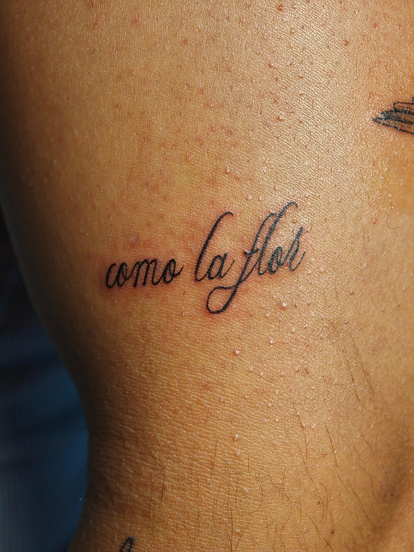 Como la flor lettering script tattoo on the upper arm by Dani Sandoval, Anaheim, California