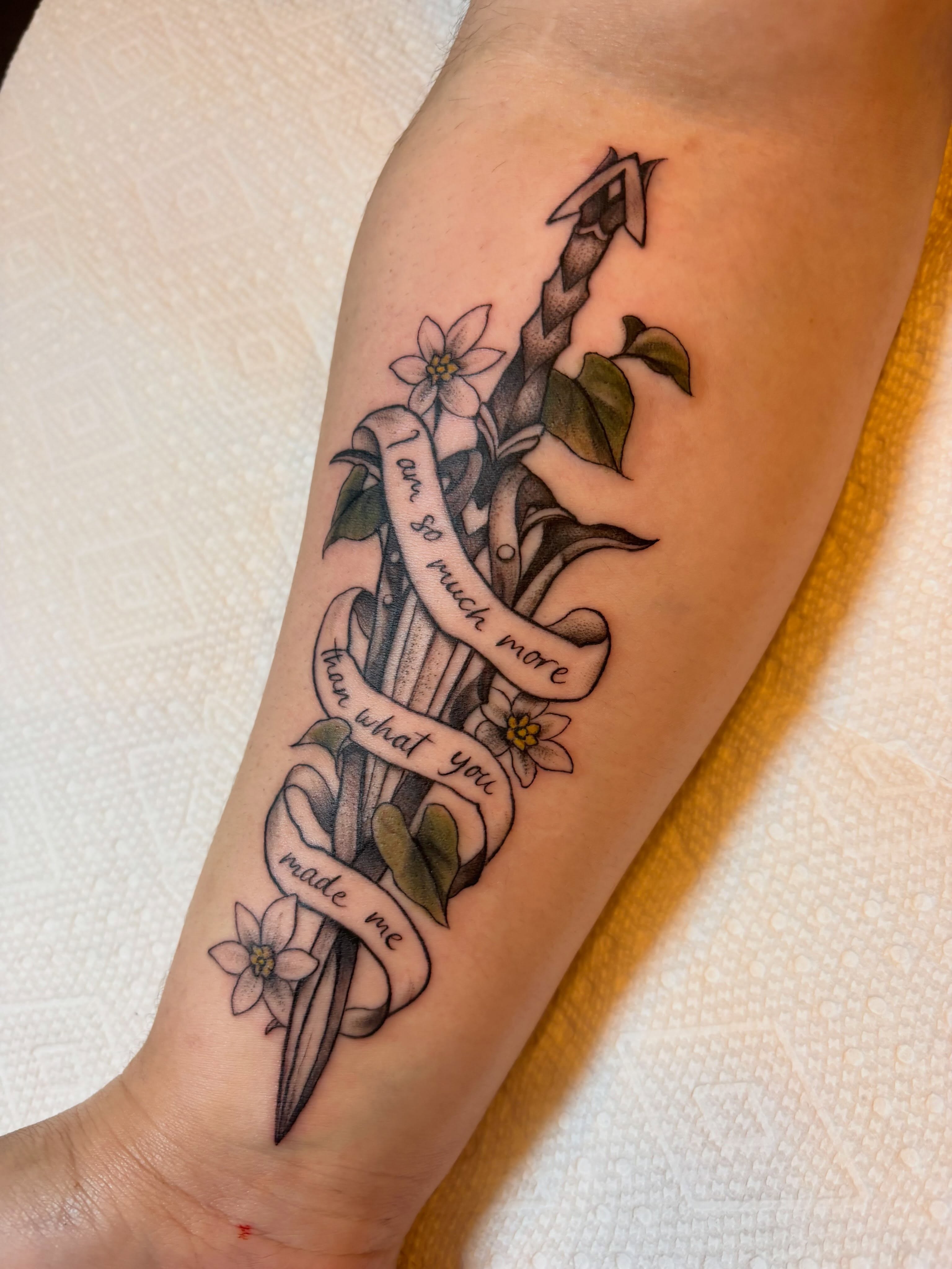 Anchor with flowers and ribbon American traditional tattoo on the forearm by Leah Leinani