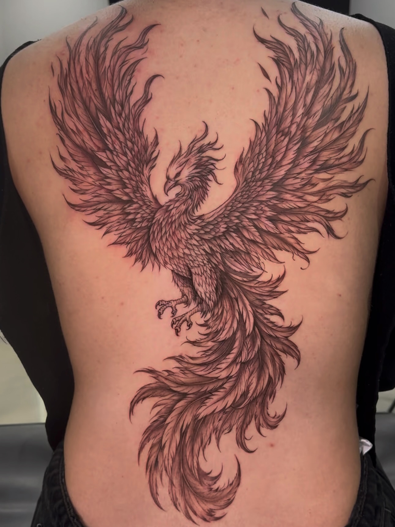 Phoenix black and grey tattoo on the back by Eyekonic Ink