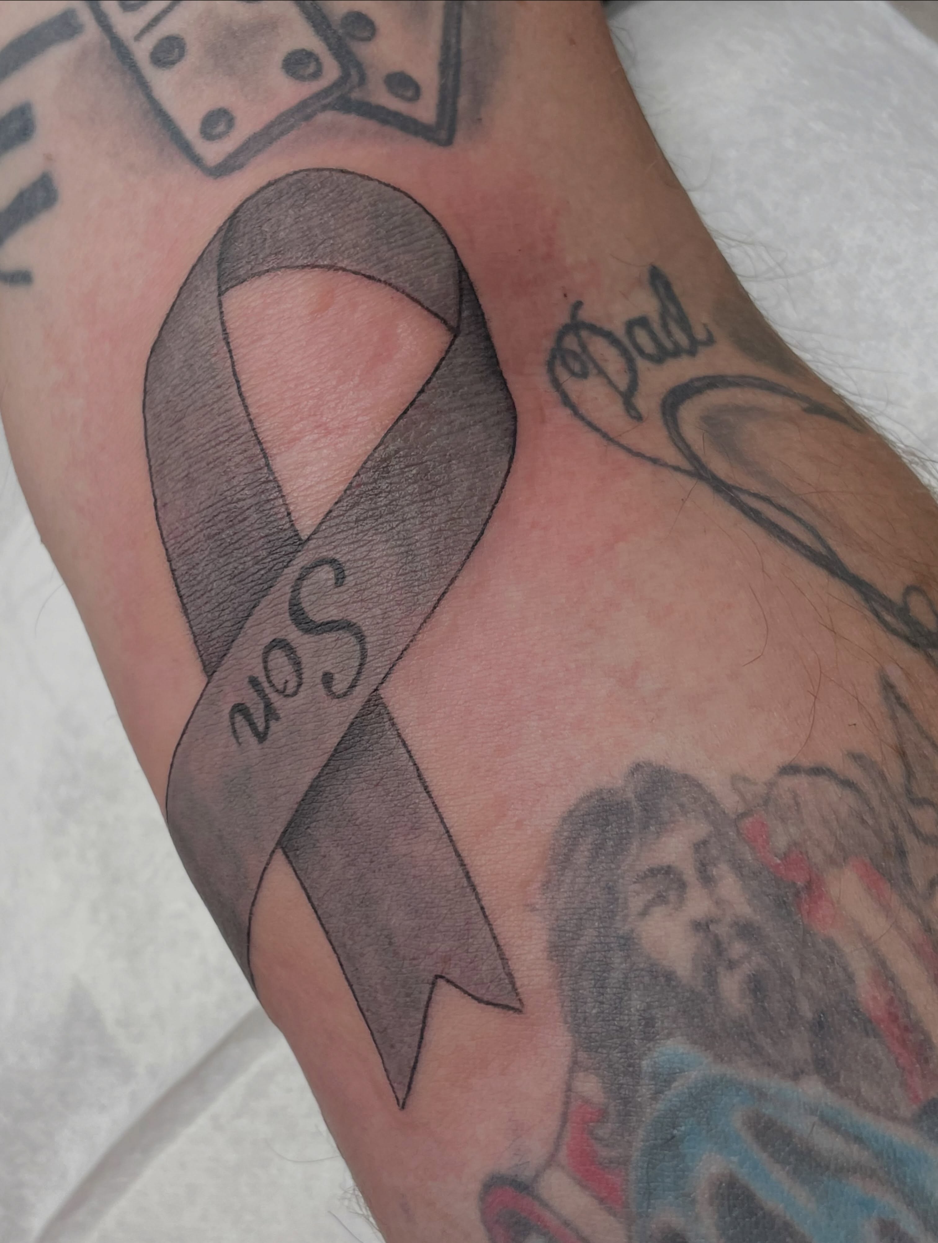 Gray ribbon black and grey tattoo on the forearm by Moses (Mo) 🇵🇭